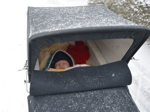 dieťatko spiace v kočíku v zime
