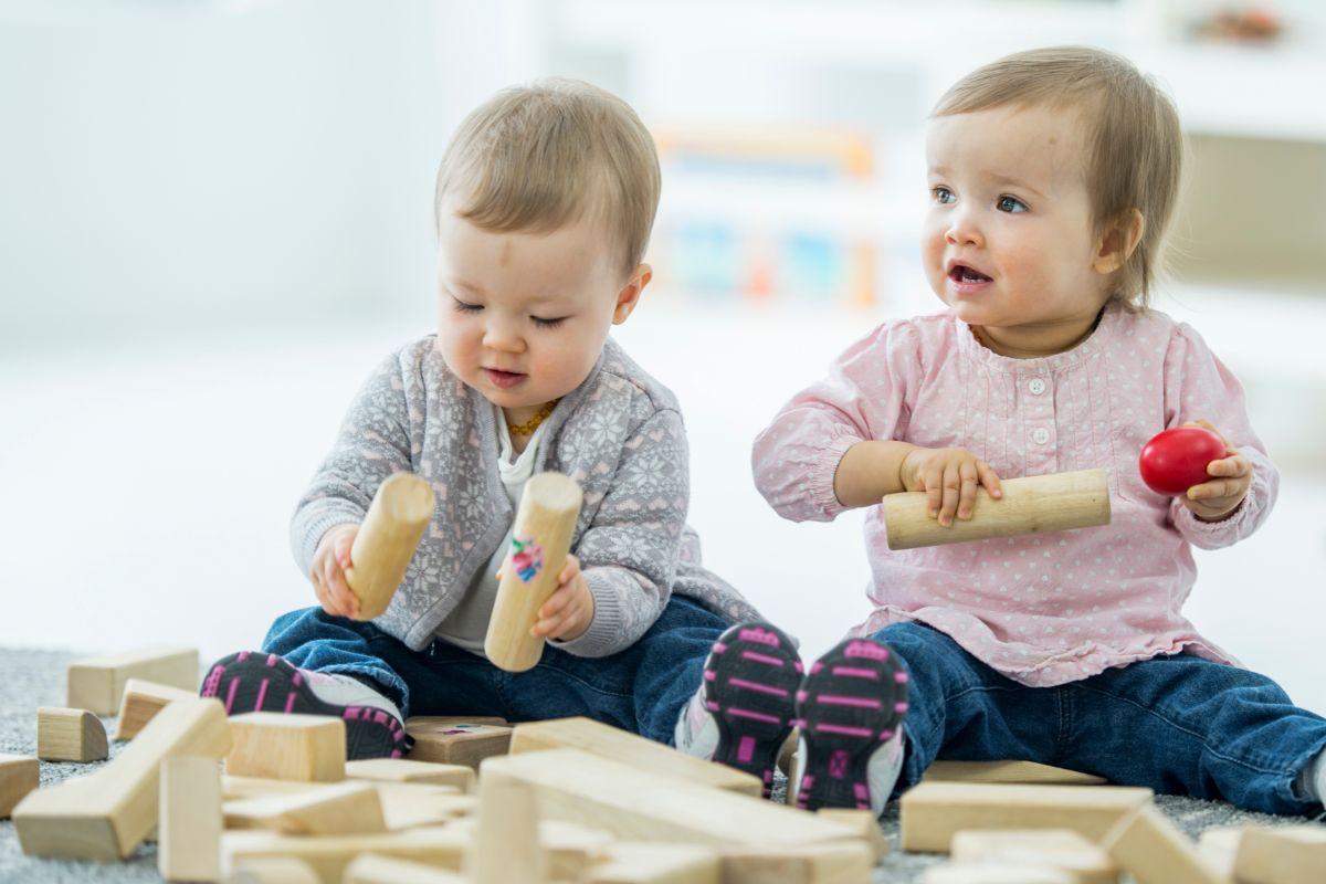 dve deti sa hrajú s drevenými hračkami